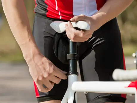 A rider adjusts his bicycle seat (Active)