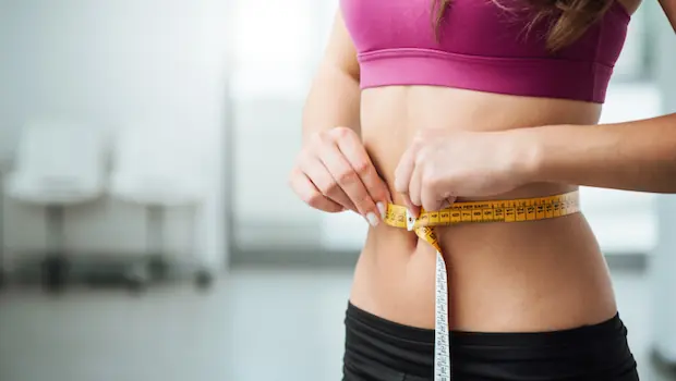 A woman measuring her stomach.